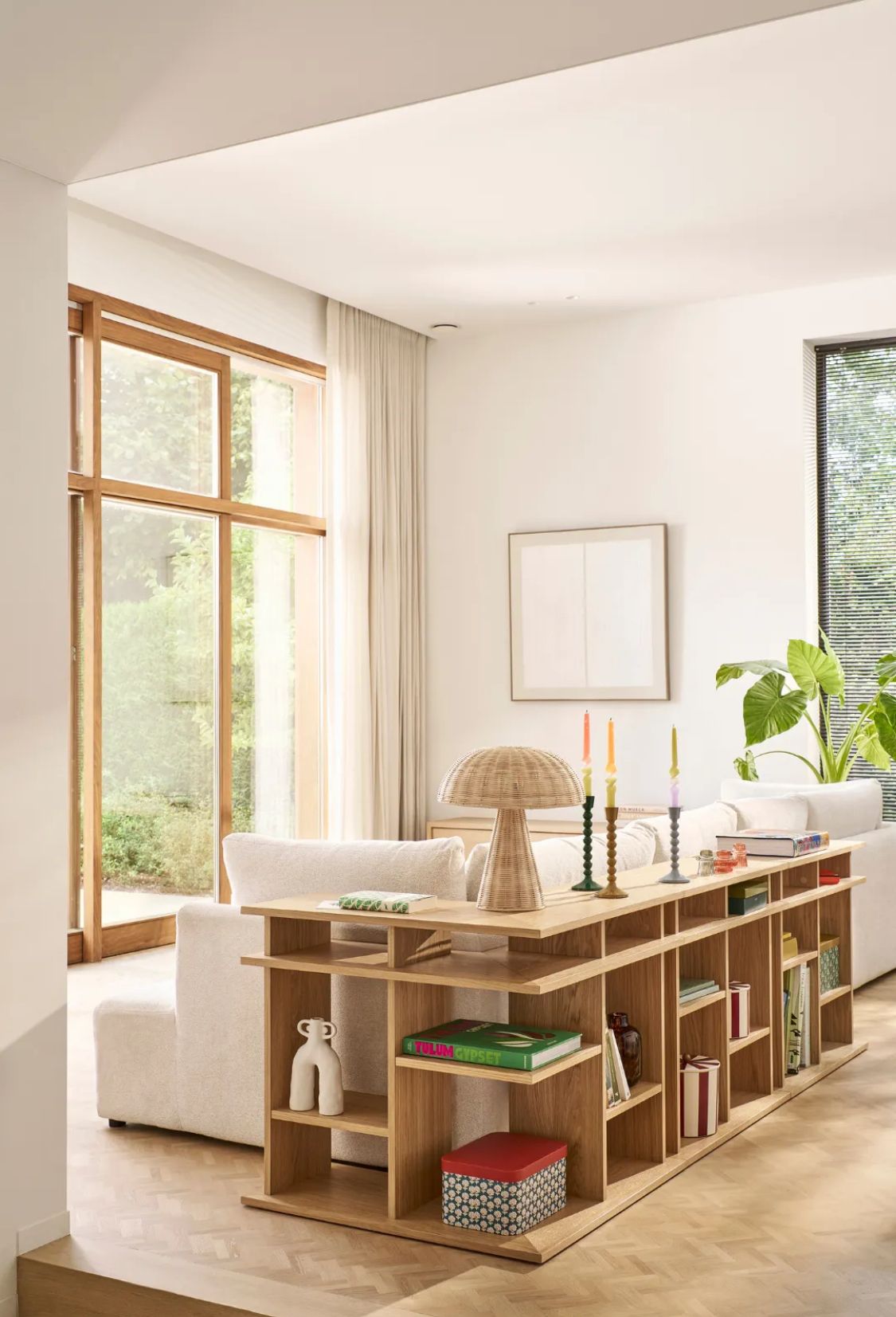 A compact apartment dining nook with a wooden table set for two, natural light coming through a nearby window, and minimal clutter on the surrounding surfaces